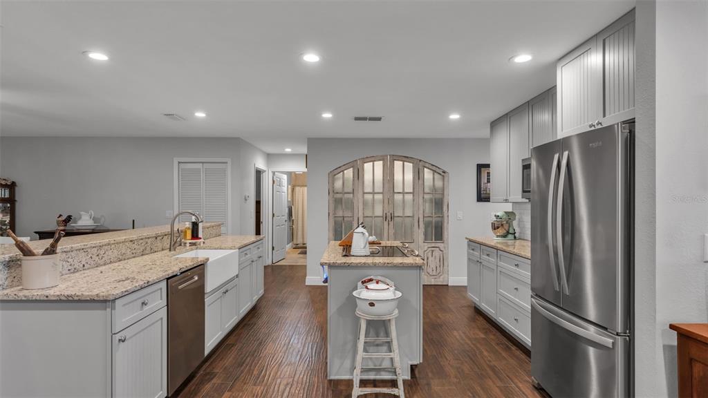815 West Socrum Loop Road Lakeland, FL 33809 - Photo 7 of 41 a kitchen with stainless steel appliances granite countertop a refrigerator a sink dishwasher a stove and white countertops with wooden floor