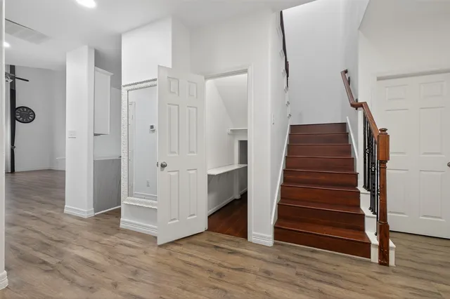a view of a hallway with wooden floor and entryway