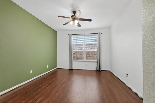 a view of room with hardwood floor and ceiling fan