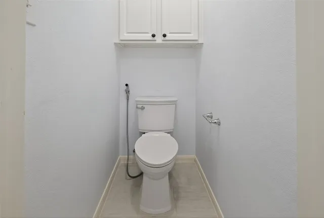 a bathroom with a granite countertop sink a toilet and shower