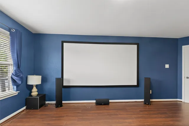 a view of an empty room with wooden floor and closet