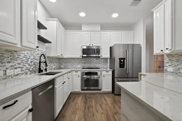 a kitchen with stainless steel appliances a refrigerator sink and microwave