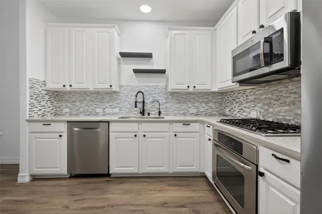 a kitchen with stainless steel appliances granite countertop a stove a sink and dishwasher