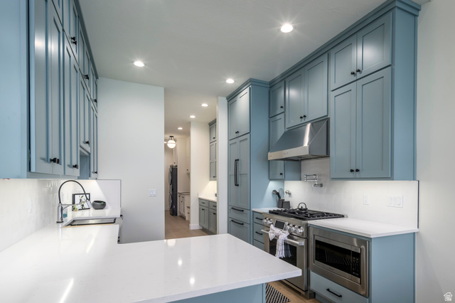 250 South Main Street, Unit 25 Alpine, UT 84004 - Photo 10 of 31 Kitchen featuring decorative backsplash, light stone countertops, stainless steel appliances, a peninsula, and recessed lighting
