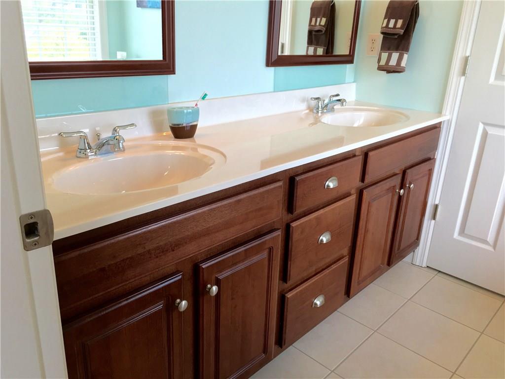 216 Grandma's Road Mount Pleasant, PA 15666 - Photo 23 of 25 The ensuite Bath Room belongs to the owners of the home. Double vanity allows for two to get ready for the day at the same time. The ceramic tile floor is low maintenance and neutral so decorating this space is simple. The mirrors throughout the Bath Rooms are all custom made cherry mirrors and add charm to each room. The door in back of this frame leads to the water closet and shower.