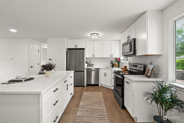 a kitchen with white cabinets stainless steel appliances and sink