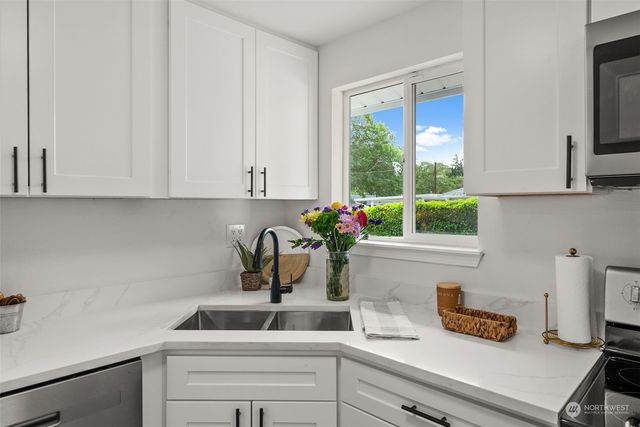 a kitchen with a white cabinets and a window