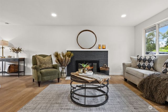 a living room with furniture a fireplace and a large window