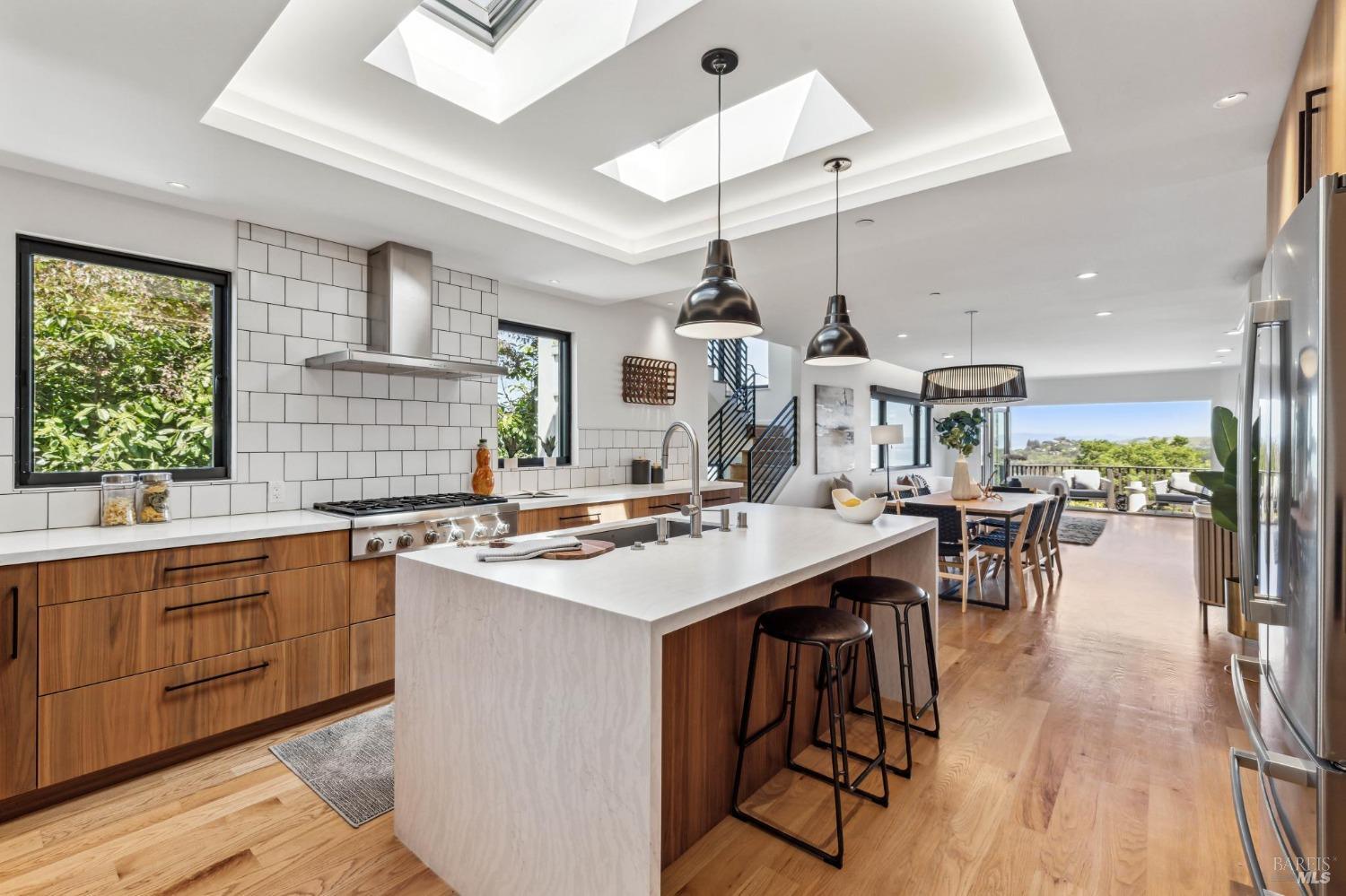 a kitchen with stainless steel appliances a table chairs and white cabinets