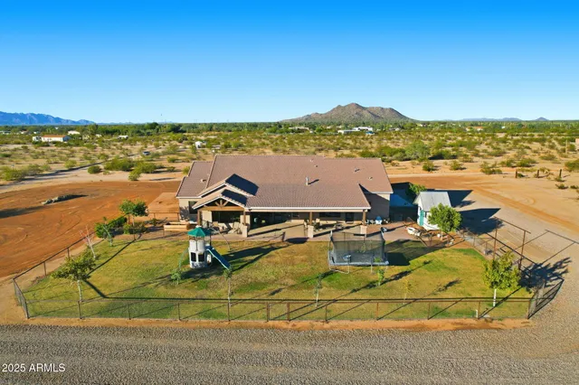an aerial view of ocean and residential houses with outdoor space