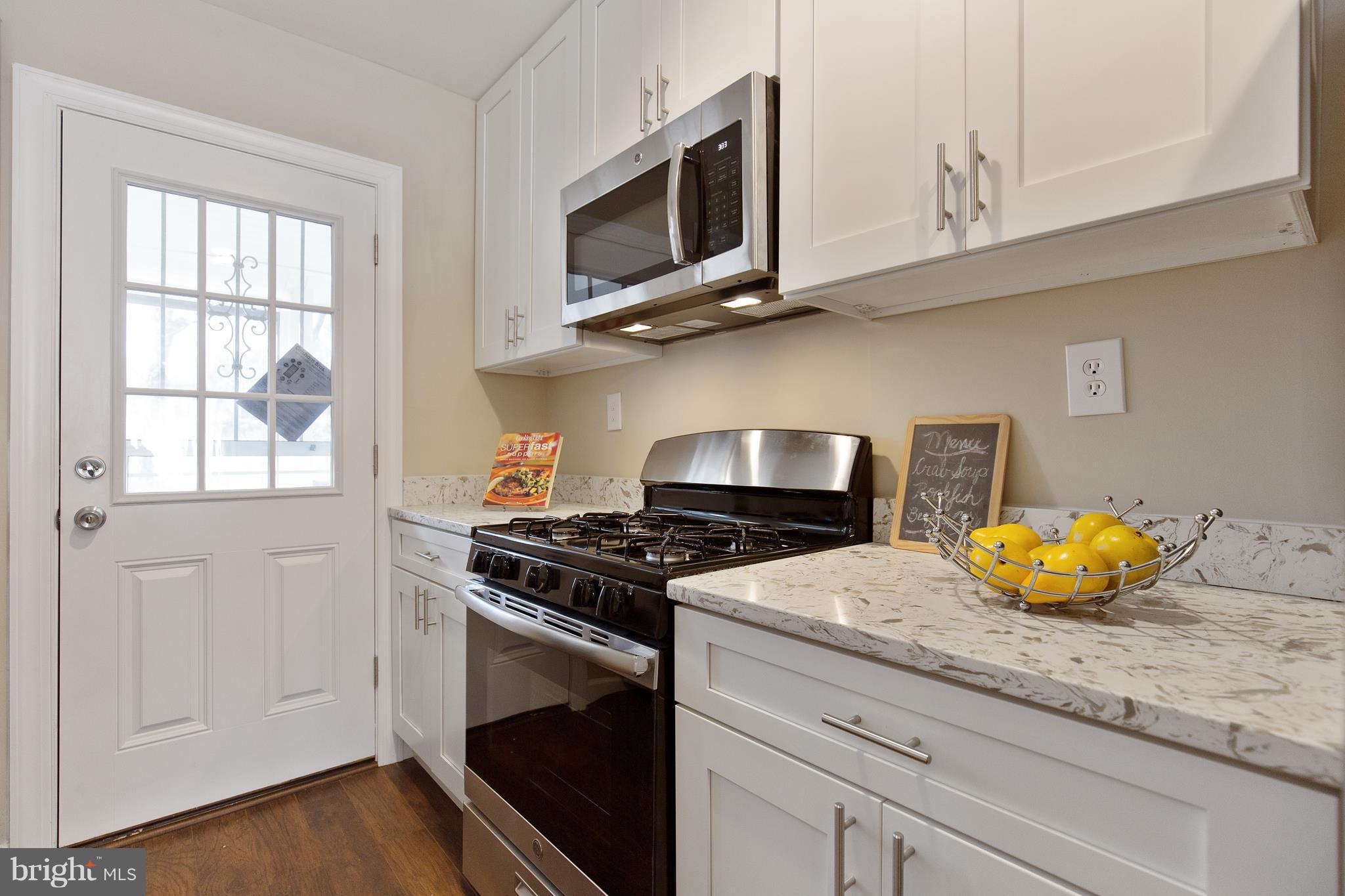 7700 Muncy Road Landover, MD 20785 - Photo 11 of 29 a kitchen with stainless steel appliances granite countertop a stove and a microwave