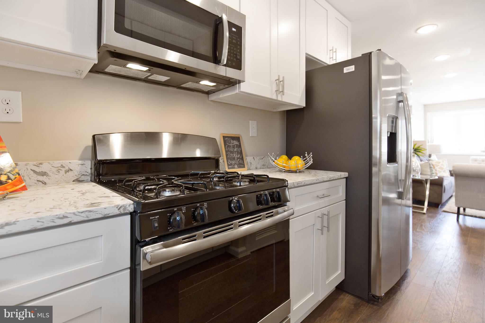 7700 Muncy Road Landover, MD 20785 - Photo 13 of 29 a kitchen with stainless steel appliances granite countertop a stove and a microwave