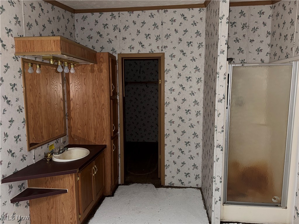 3690 Anderson Anthony Road Leavittsburg, OH 44430 - Photo 12 of 18 Full bathroom with wallpapered walls, vanity, a stall shower, and crown molding