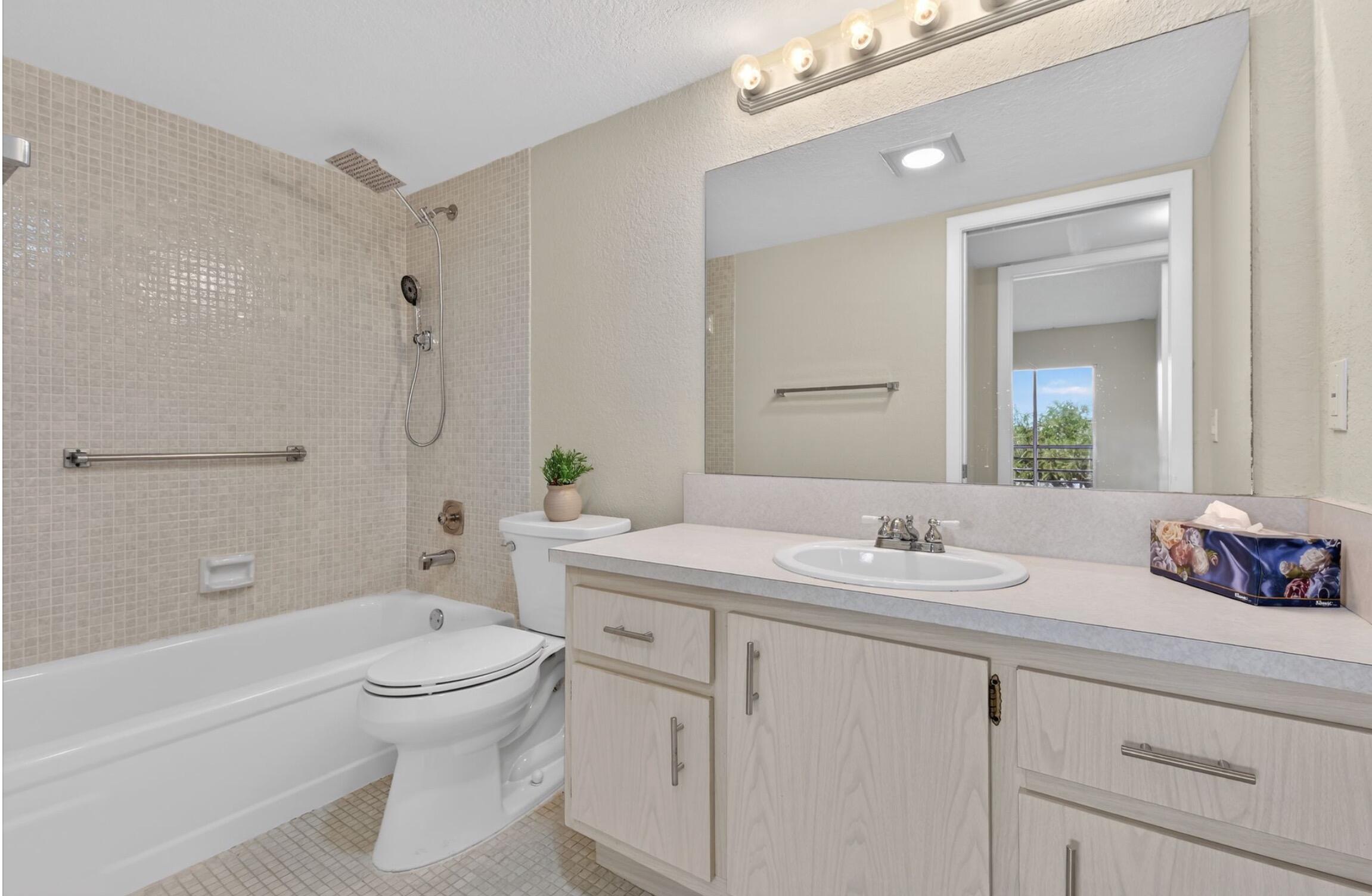 2012 Hythe A, Unit 2012 Boca Raton, FL 33434 - Photo 13 of 15 a bathroom with a sink a toilet and shower