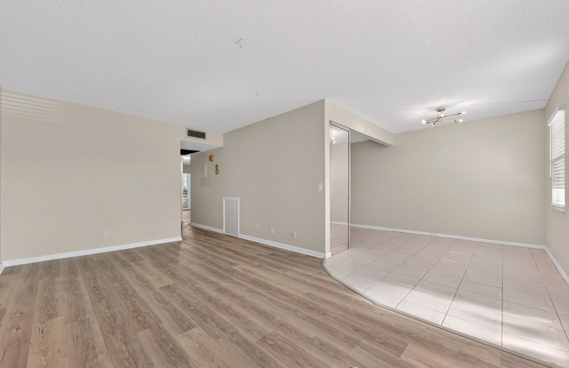 2012 Hythe A, Unit 2012 Boca Raton, FL 33434 - Photo 4 of 15 a view of an empty room with wooden floor