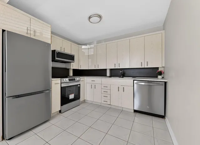 a kitchen with white cabinets and white appliances