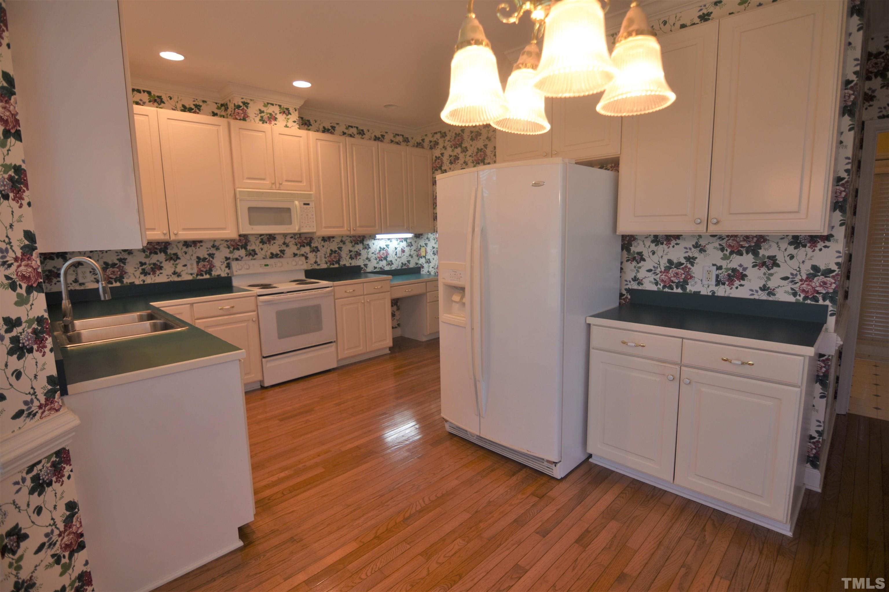 1025 Red Brick Road Garner, NC 27529 - Photo 11 of 30 a kitchen with kitchen island white cabinets and stainless steel appliances
