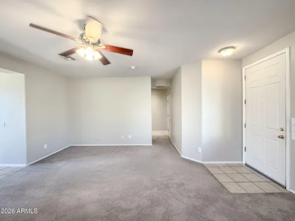 an empty room with windows and fan