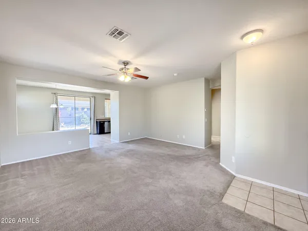 an empty room with a chandelier fan and closet area