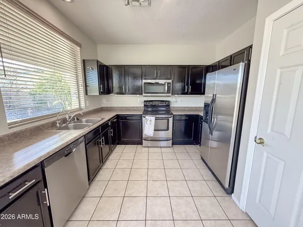 a large kitchen with granite countertop a stove a sink and a refrigerator