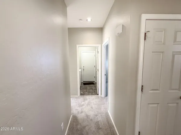 en empty room with windows and chandelier fan