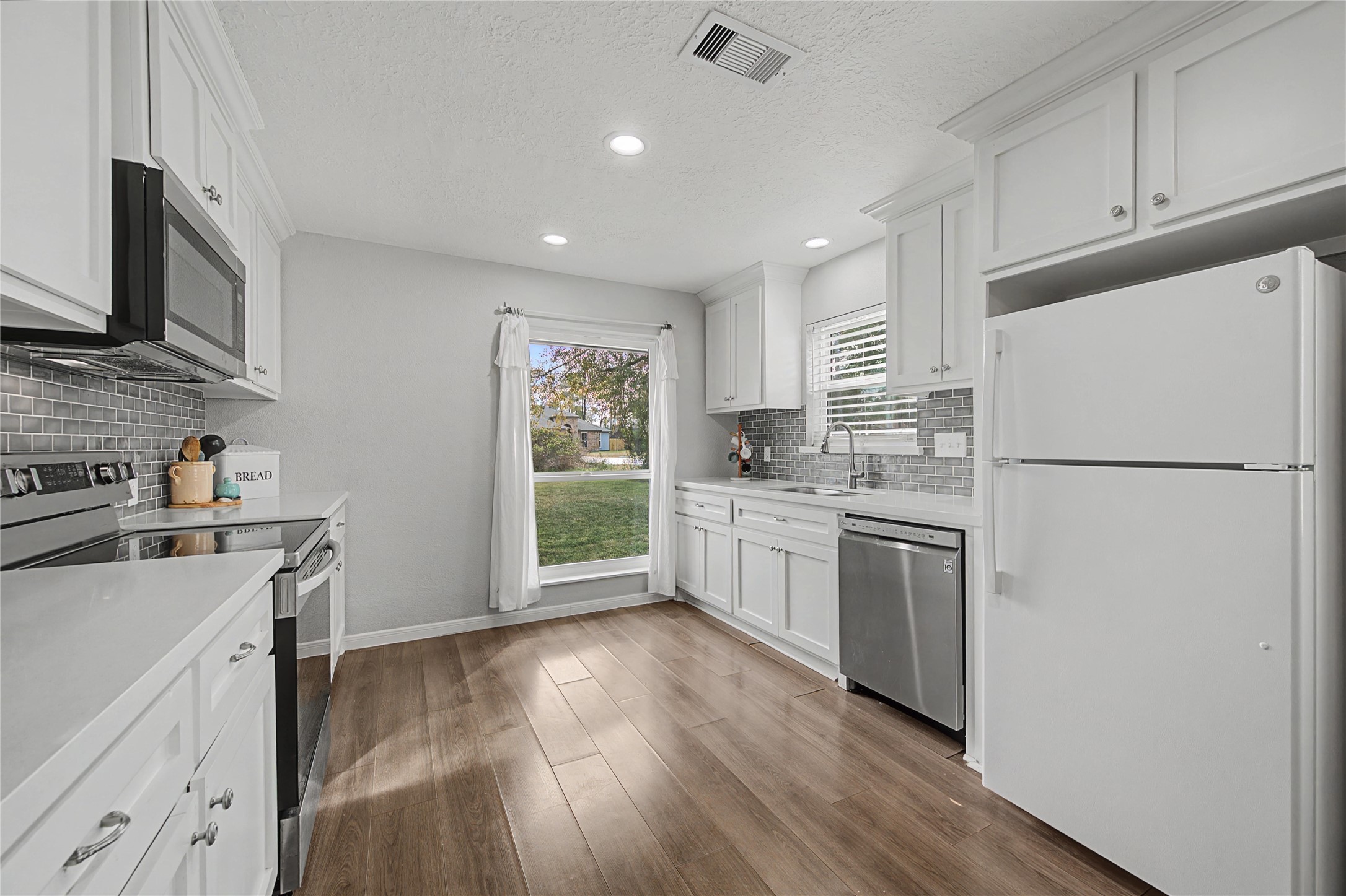 1719 Eastvale Drive Spring, TX 77386 - Photo 11 of 34 The kitchen opens seamlessly to the main living space and offers modern updates with quartz countertops, refreshed cabinetry, and tile backsplash. The refrigerator will convey with the home.