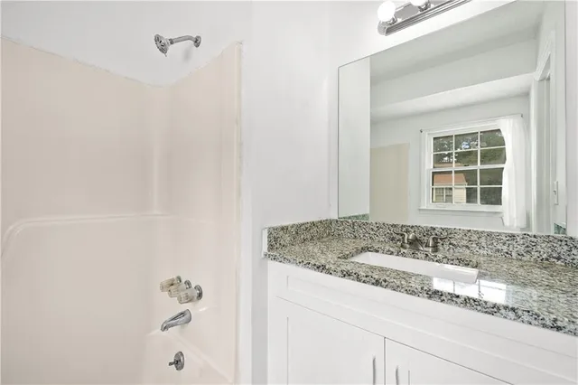 a bathroom with a granite countertop sink and vanity