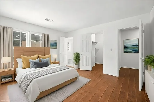 a bedroom with a bed and wooden floor