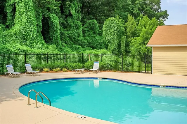 a view of a swimming pool with lawn chairs under an umbrella