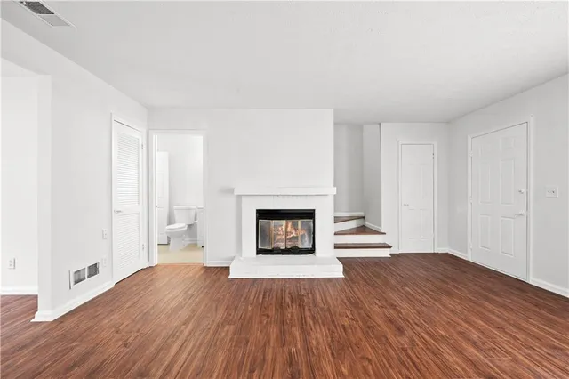 a view of a livingroom with wooden floor and a fireplace