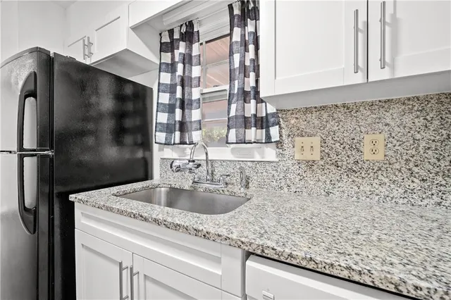 a bathroom with a granite countertop sink a vanity and shower