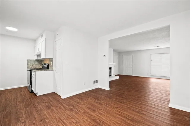 a view of empty room with wooden floor and window