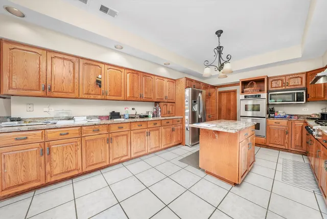 a kitchen with stainless steel appliances granite countertop a stove top oven a sink dishwasher and cabinets with wooden floor