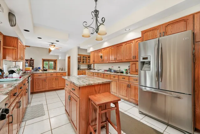 a kitchen with stainless steel appliances a stove a refrigerator a sink a oven with a dining table and chairs