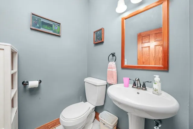 a bathroom with a toilet sink and mirror