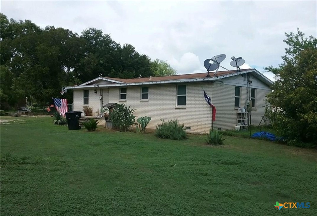 9312 Hogan Road Temple, TX 76502 - Photo 1 of 1 a white house with a small yard and trees in the background