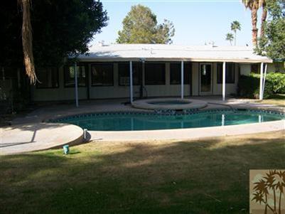 68431 Rodeo Road Cathedral City, CA 92234 - Photo 5 of 6 a view of a white house with a yard and a large tree