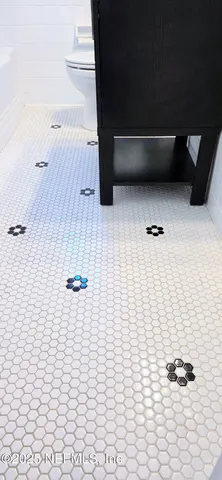 a view of a backyard with large trees and a barn