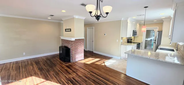 a view of a kitchen with a sink and a fireplace