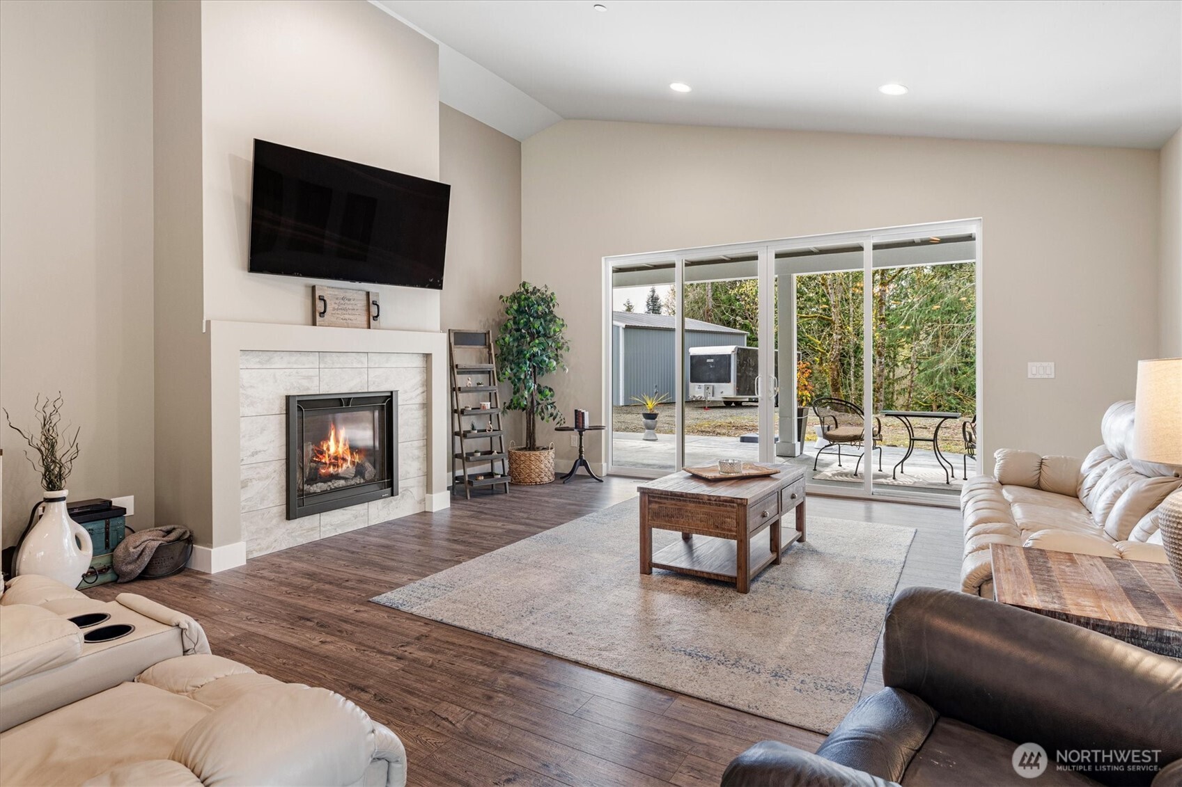 20025 Southeast 232nd Street Maple Valley, WA 98038 - Photo 14 of 40 a living room with furniture a fireplace and a flat screen tv