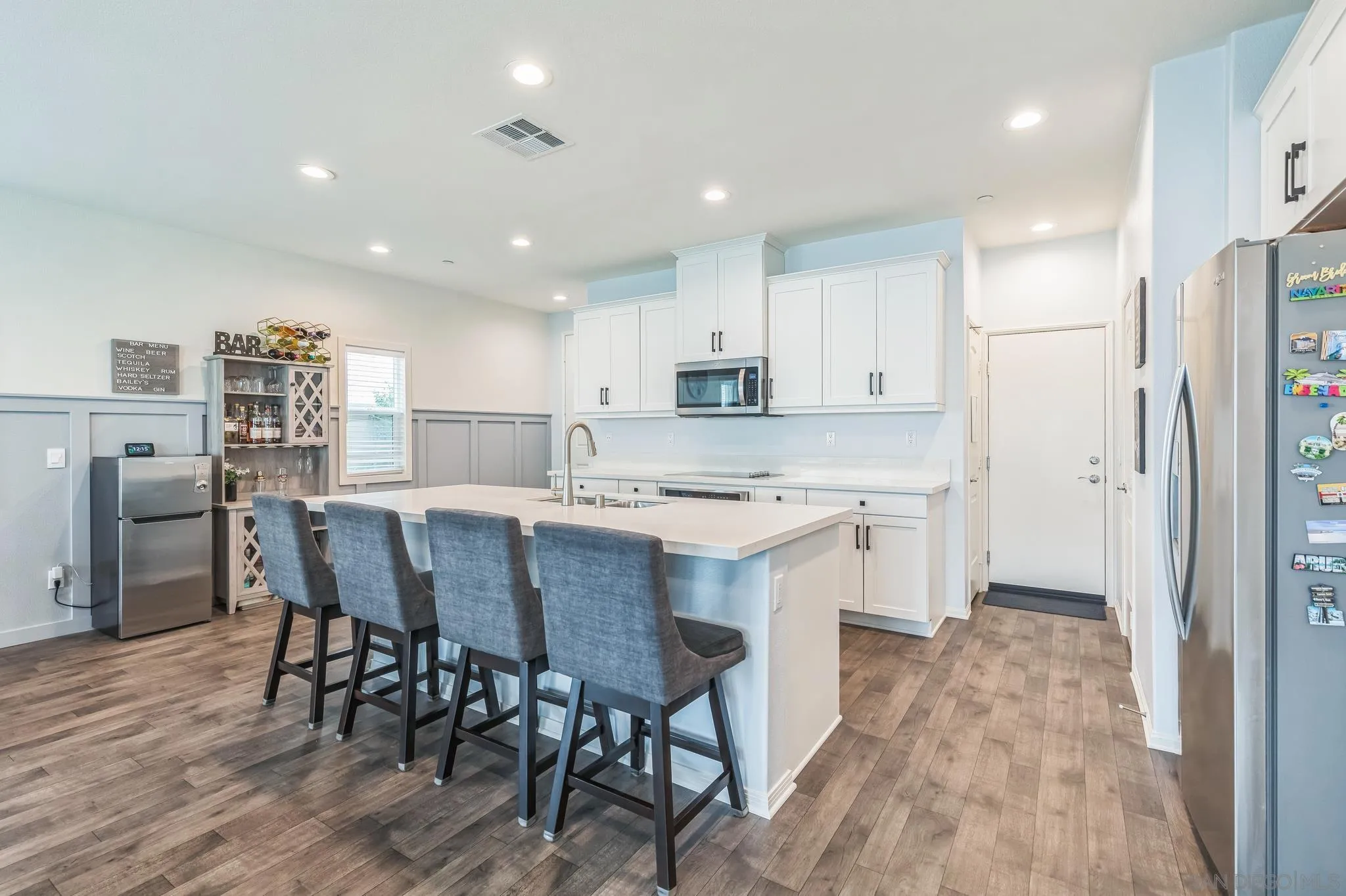 5522 Starlight Place Bonsall, CA 92003 - Photo 11 of 32 a kitchen with a table chairs refrigerator and microwave