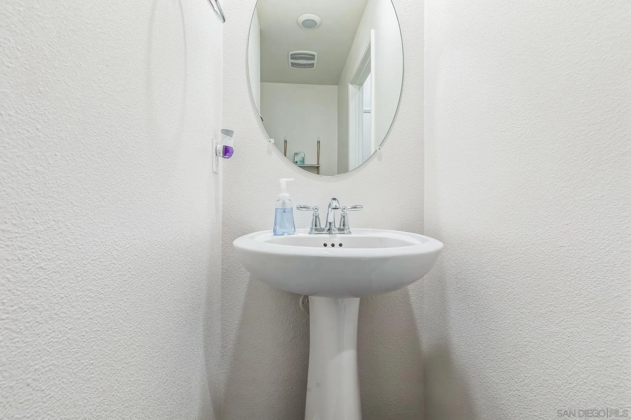 5522 Starlight Place Bonsall, CA 92003 - Photo 29 of 32 a bathroom with a sink and a mirror