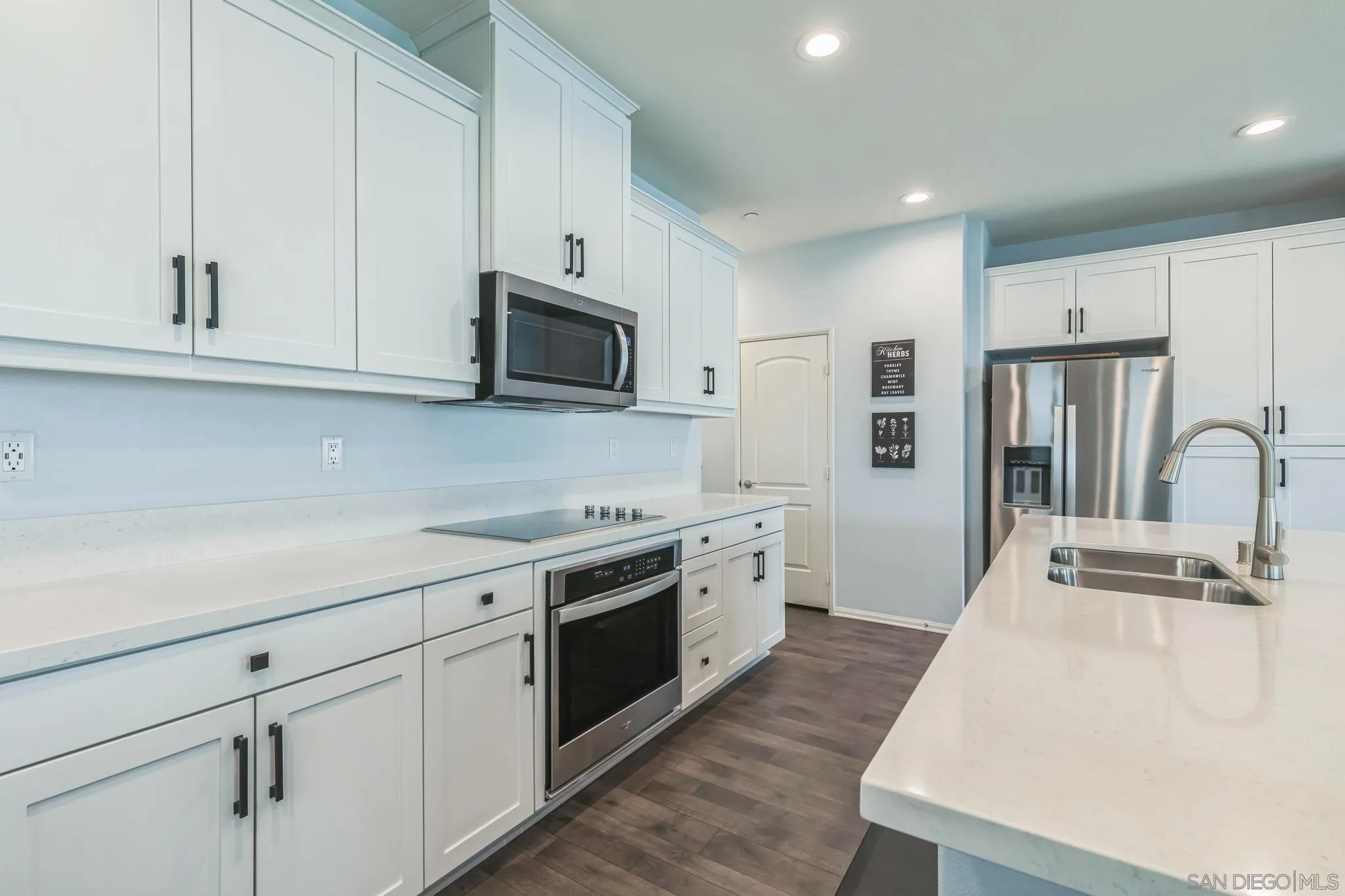 5522 Starlight Place Bonsall, CA 92003 - Photo 8 of 32 a kitchen with cabinets stainless steel appliances a sink and a stove