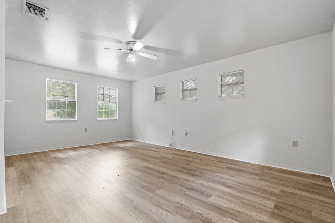 1304 Delano Street, Unit B Austin, TX 78721 - Photo 6 of 15 a view of an empty room with wooden floor and window