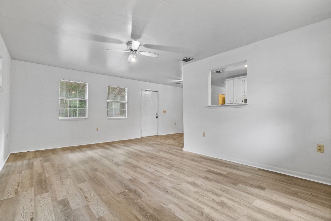 1304 Delano Street, Unit B Austin, TX 78721 - Photo 7 of 15 an empty room with wooden floor fan and windows