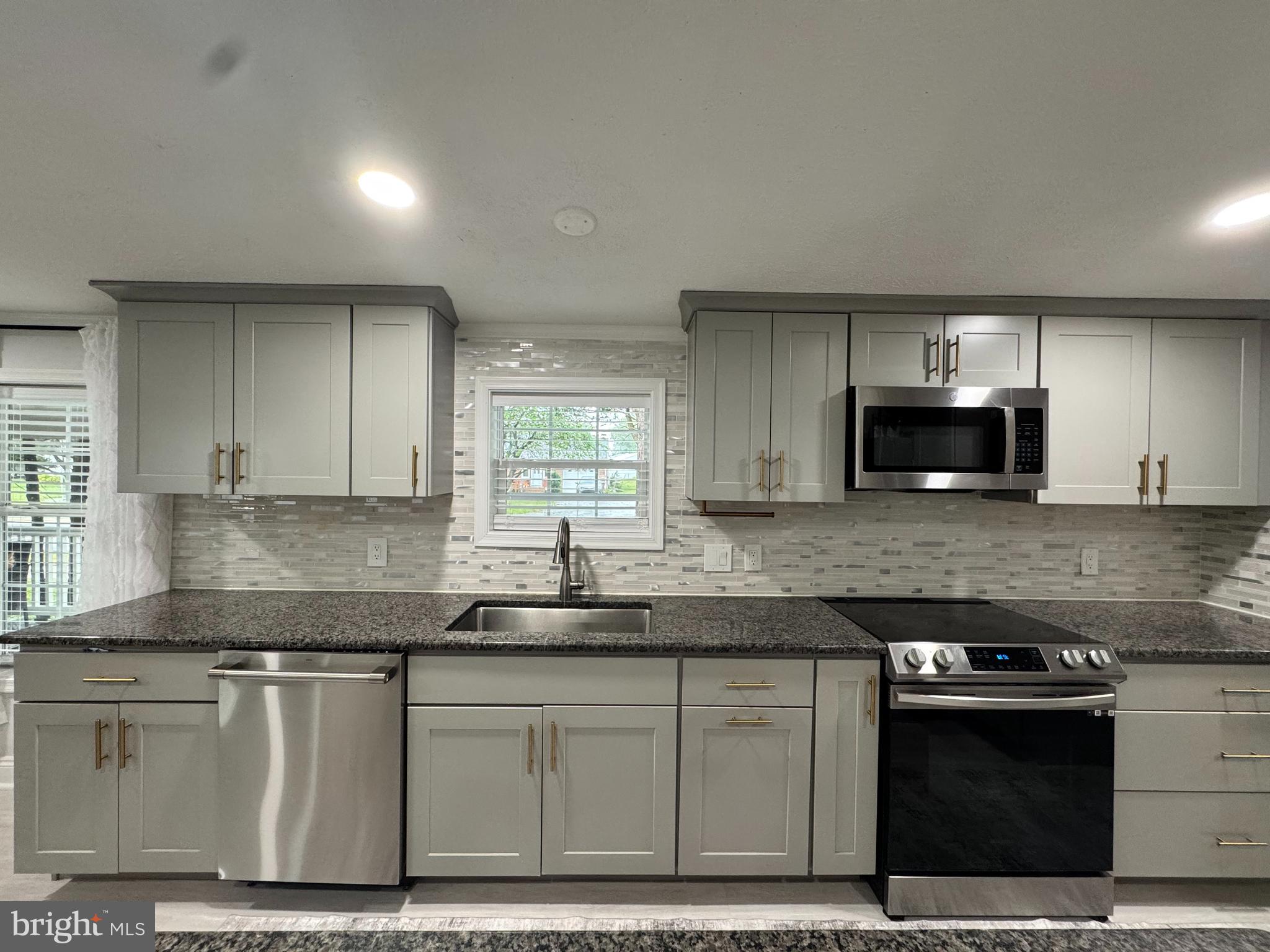 5 Emery Circle Delmar, DE 19940 - Photo 10 of 49 a kitchen with granite countertop a sink cabinets and stainless steel appliances