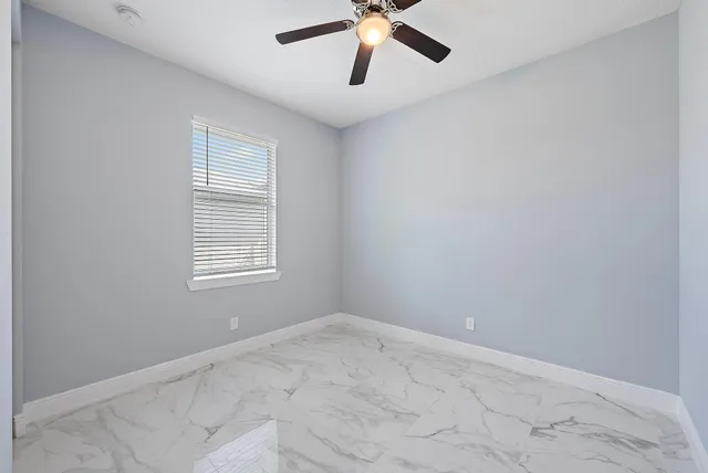 a view of a room with a window and a ceiling fan
