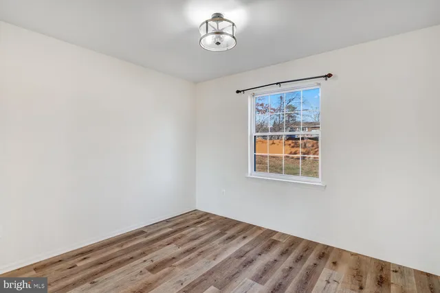 a view of a room with wooden floor and windows
