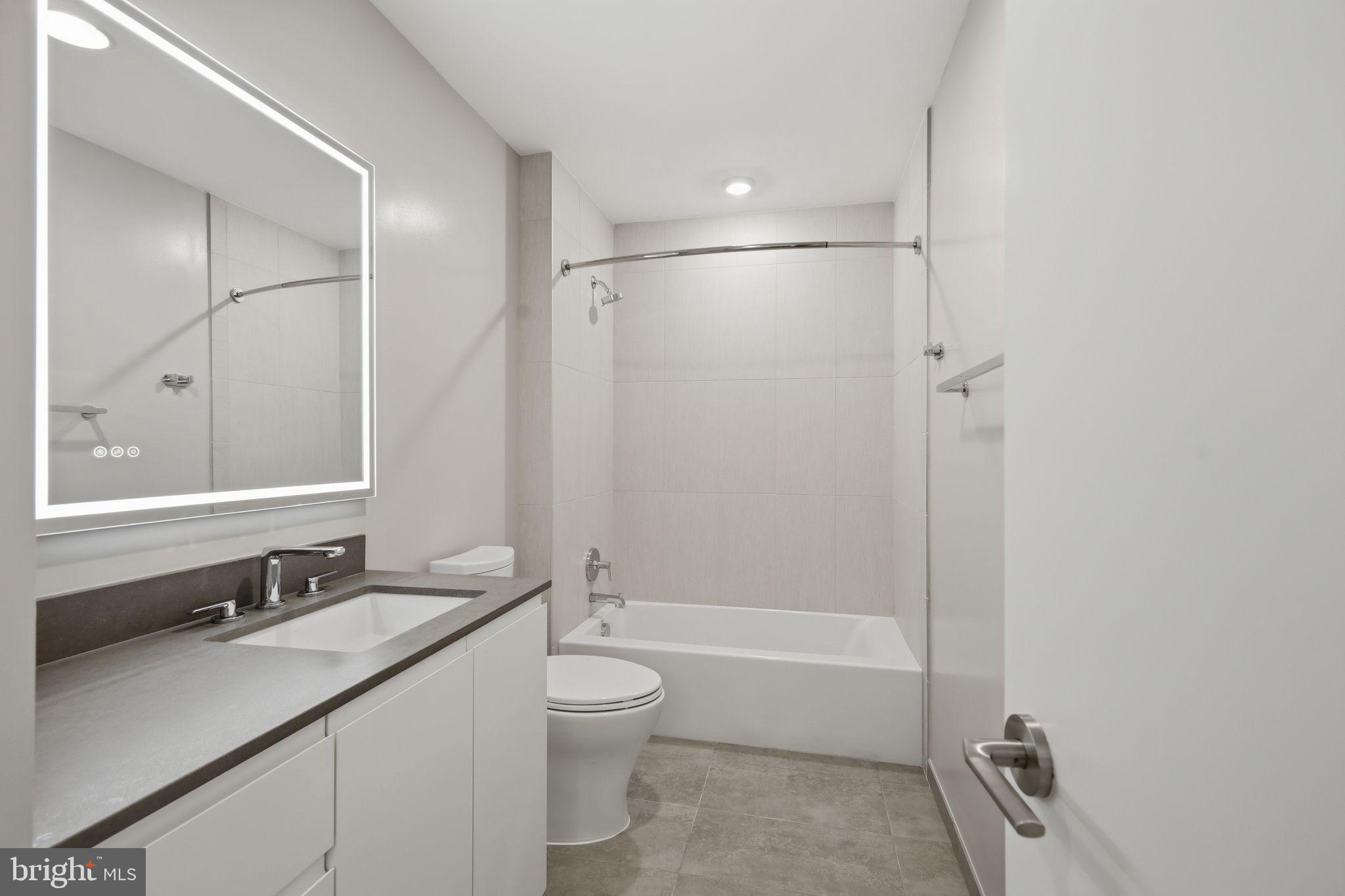 950 3rd Street Northwest, Unit 907 Washington, DC 20001 - Photo 33 of 34 a bathroom with a granite countertop sink a toilet and shower