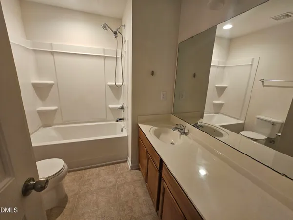 a bathroom with a tub sink toilet and a mirror
